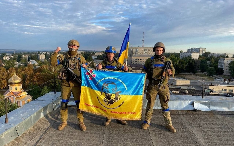 Ukrainian troops raise the national flag in the centre of Kupiansk