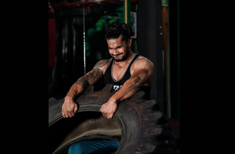 A man screams mid-exercise as he focuses during his workout (Illustrative) (photo credit: PIXAHIVE)