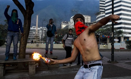 A demonstrator throws an incendiary device during clashes with Venezuelan National Bolivarian Guard (GNB) during a protest against president Nicolas Maduro in Caracas, Venezuela. The<br />
Venezuelan government accuses the opposition of attempting a coup d'etat to topple President Nicolas Maduro, who narrowly won election last year as the hand-picked successor to left-wing populist Hugo Chavez, who died in office March 2013.