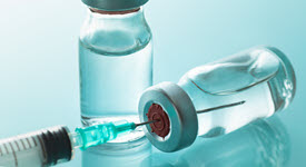 bottles of vaccine and a needle