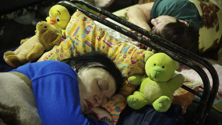 In this photo taken early morning Friday, Jan. 11, 2013, homeless women sleep with their teddy-bears in a shelter called 'The Heated Street' in Budapest, Hungary. Hungary considers constitutional change to allow authorities to force homeless off the streets. (AP Photo/Bela Szandelszky)