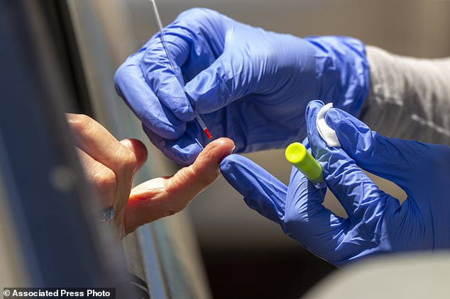 FILE - In this Wednesday, May 20, 2020 file photo, a health worker takes a blood sample for a COVID-19 antibody test in Los Angeles. An antibody test might show if you had COVID-19 in the recent past, which most experts think gives people some protection from the virus. (AP Photo/Damian Dovarganes)