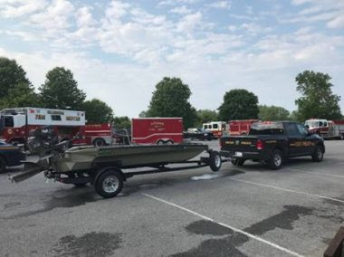 Truck with small boat on trailer in parking lot