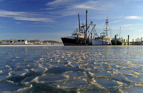 Surrounded by ice, commercial fishing boats are docked in their slips in Lake Montauk in Montauk, N.Y. earlier this year. (AP Photo/Julie Jacobson)