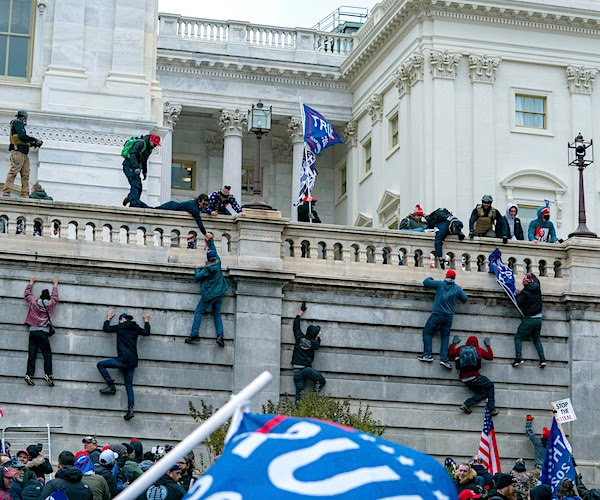 People climbing the walls of the Capitol