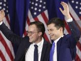Democratic presidential candidate former South Bend, Ind., Mayor Pete Buttigieg waves with husband Chasten Buttigieg, left, at a primary night election rally in Nashua, N.H., Tuesday, Feb. 11, 2020. (AP Photo/Mary Altaffer)