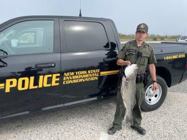 ECO stands next to truck holding large white fish