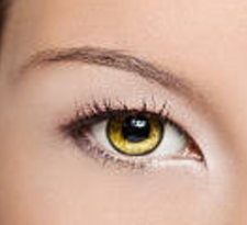 Close-up photo of the amber-colored eye of a young woman.