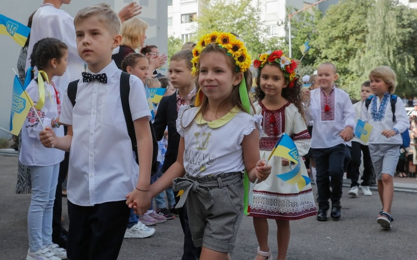 Pupils wave flags on their first day of school in Kyiv yesterday.