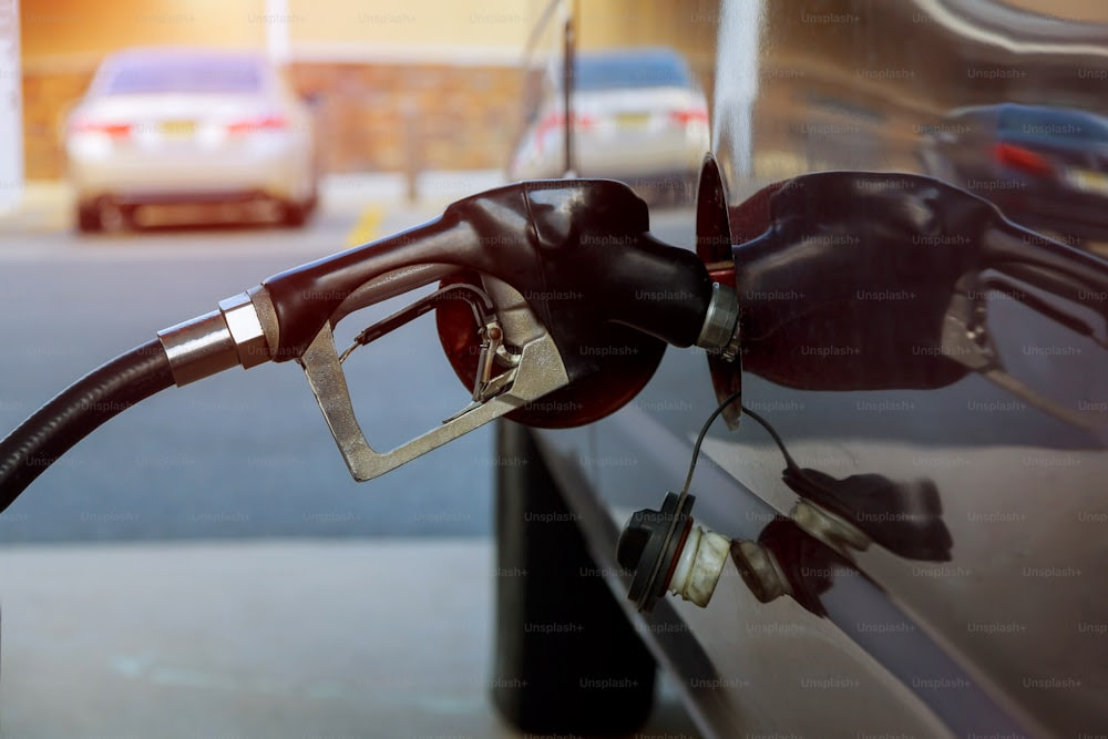 Le carburant de ravitaillement de la voiture sur la station-service de pompage d’essence remplit le gaz dans le réservoir