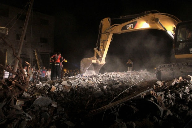 Palestinians search the for survivors amongst the remains of a family home in Gaza City.