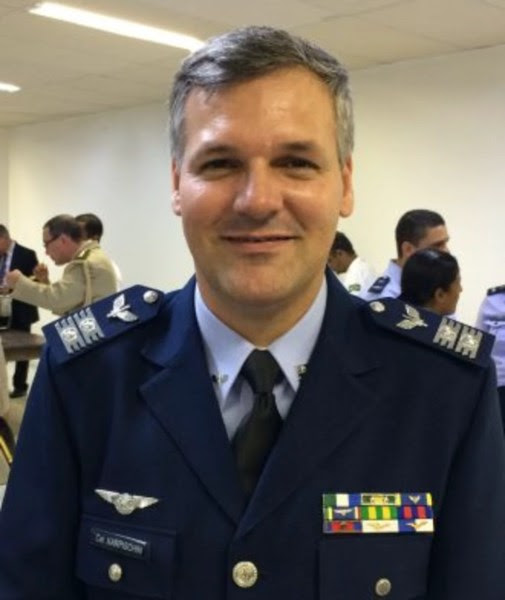 Ivan Lucas Karpischin é um homem branco na faixa dos 40, 50 anos. Ele tem cabelos grisalhos e olhos escuros. Ivan veste uniforme da aeronáutica azul. 