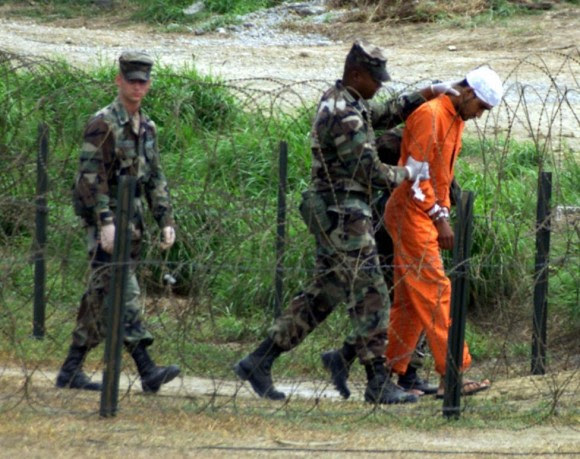 Policía Militar en el campamento de rayos X en la Base Naval de Guantánamo, en Cuba, llevar a un detenido a una sala de interrogatorios, 06 de febrero 2002. Foto: Marc Serota/ Reuters.