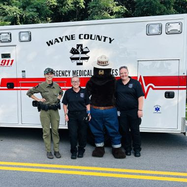 Rangers, EMS, and Smokey Bear in front of ambulance