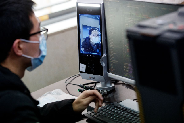 A software engineer works on a facial recognition program that identifies people when they wear a face mask at the development lab of the Chinese electronics manufacturer Hanwang (Hanvon) Technology in Beijing as the country is hit by an outbreak of the novel coronavirus (COVID-19), China, March 6, 2020. REUTERS/Thomas Peter
