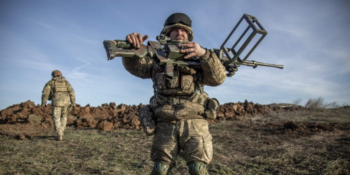 A Ukrainian service member holding a firearm.