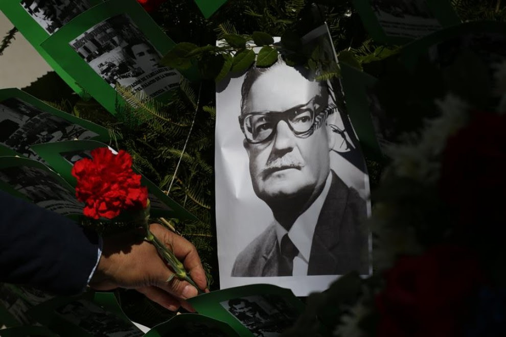 Un hombre deja una flor sobre la imagen del presidente chileno Salvador Allende, este viernes en Santiago. Chile conmemora el 47 aniversario del golpe de Estado de Augusto Pinochet, que derrocó al Gobierno de Salvador Allende, en plena pandemia de corona