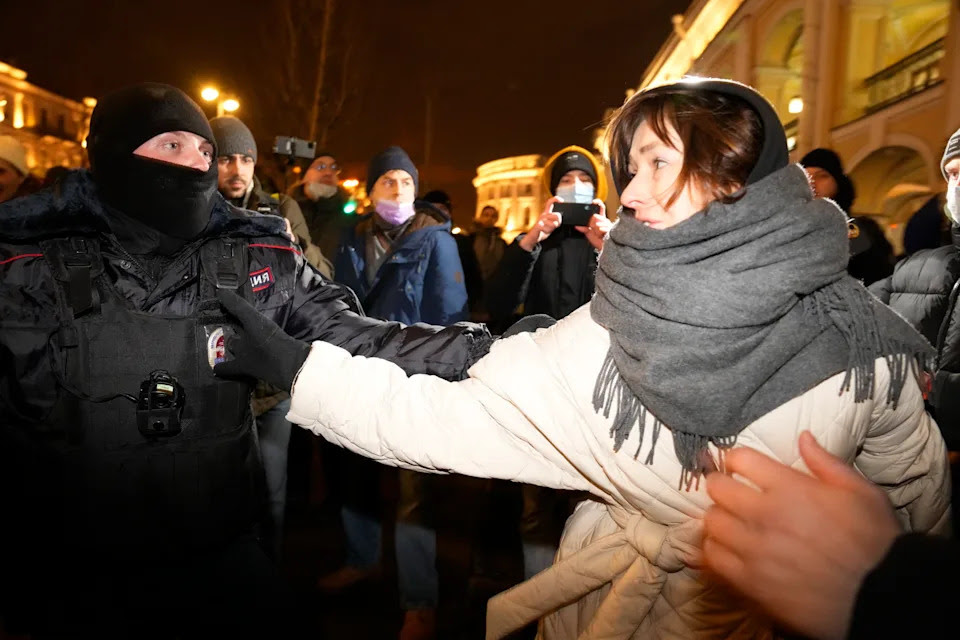 A police officer detains a woman during a gathering in St. Petersburg, Russia, Thursday, Feb. 24, 2022, after Russia's attack on Ukraine. Hundreds of people gathered in the center of Moscow on Thursday, to protest against Russia's attack on Ukraine and many of the demonstrators were detained. Similar protests took place in other Russian cities, where activists were also arrested. (AP Photo/Dmitri Lovetsky)