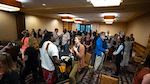 A large group of people talk and mingle in a session of the 2022 NAAEE Conference in Tucson, Arizona.