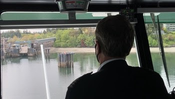 Photo of ferry captain in pilothouse looking out window