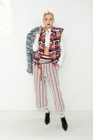 Image may contain Formal Wear Suit Clothing Tie Accessories Head Face Person Gigi Hadid and Pants