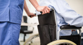 Image of nurse pushing patient in wheelchair