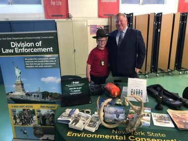 ECO and young kid standing at informational booth