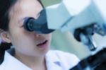 Female student working with a microscope