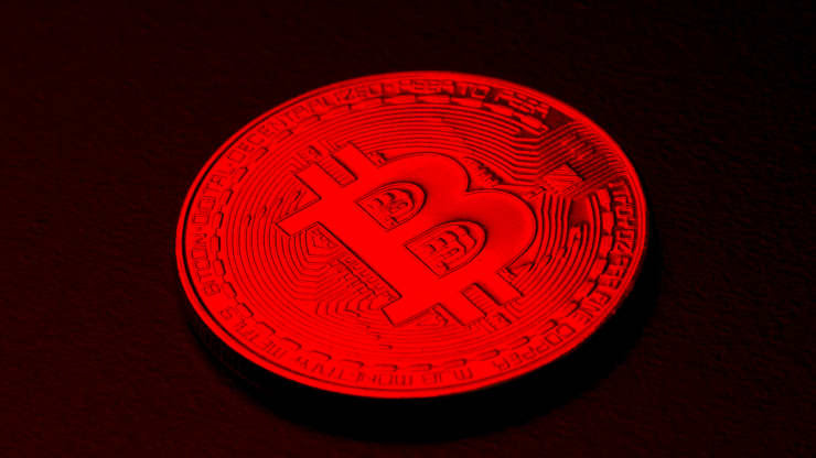 A coin with the letter ''B'' on it is cast in a red light