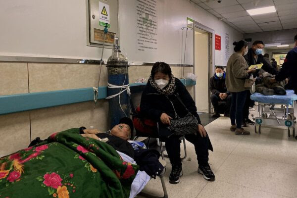 Một bệnh nhân nhiễm COVID-19 nằm trên giường ở một hành lang tại Bệnh viện Công nhân Đường Sơn ở thành phố Đường Sơn, đông bắc Trung Quốc hôm 30/12/2022. (Ảnh: Noel Celis/AFP qua Getty Images)