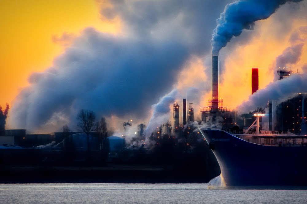 Un grand bateau dans un plan d’eau près d’une usine