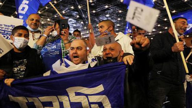  Supporters of Israeli Prime Minister Benjamin Netanyahu's Likud party react following the announcement of the exit polls in general elections Jerusalem. March 23, 2021. 