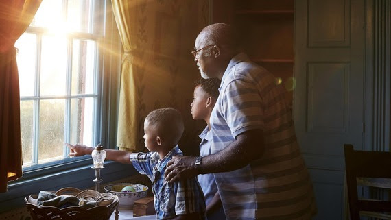 A Grandfather and grandsons look out the window at Rankin House.