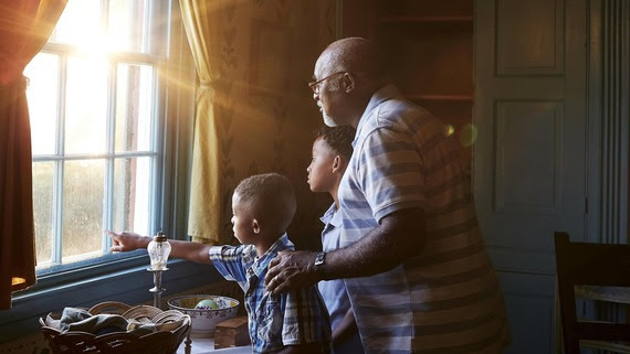 A Grandfather and grandsons look out the window at Rankin House.