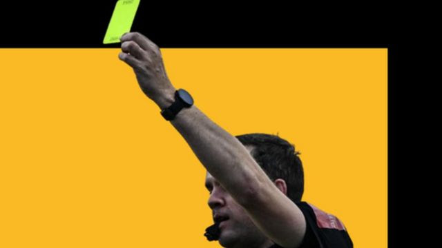 Árbitro de futebol mostrando cartão amarelo