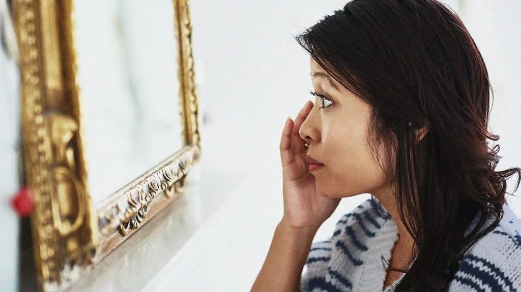 A person applying niacinamide and retinol skincare products to their face.