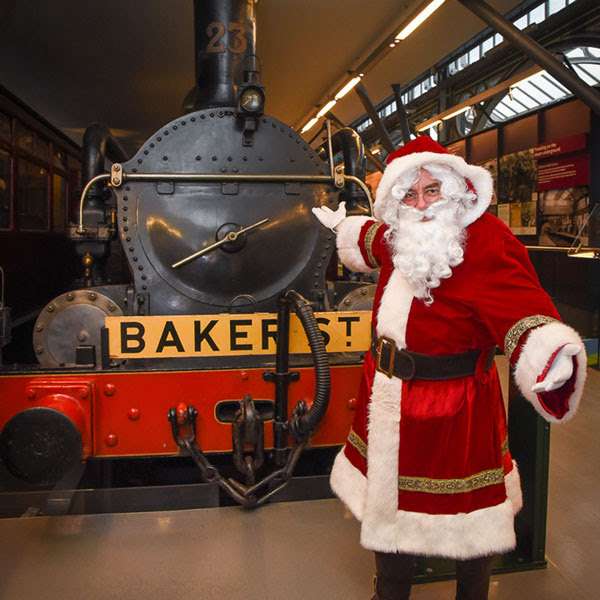 Father Christmas standing in front of a historic train