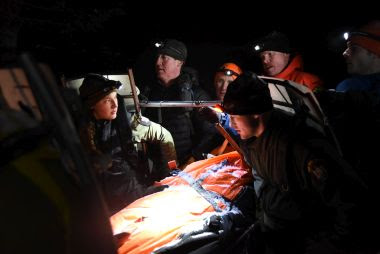 Rangers carrying out injured hiker during night rescue