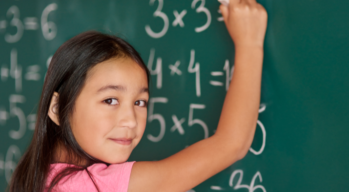 Girl multiplying at chalkboard