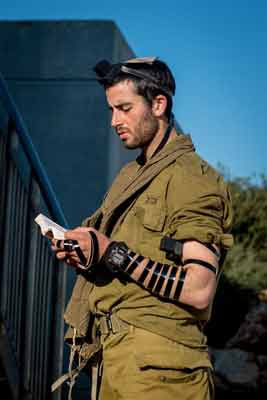 An
                      Israeli soldier wearing tefillin (phylacteries)
                      recites the morning prayers.