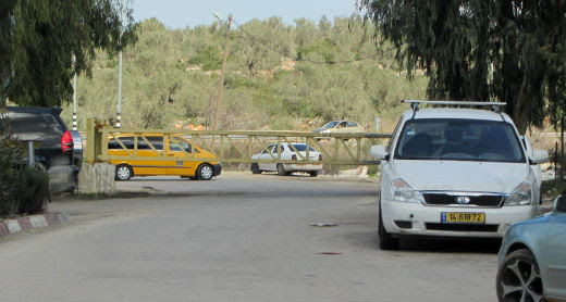 Taxi waiting for passengers outside the closed gate at the main entrance to ‘Azzun. Photo by Abdulkarim Sadi, B’Tselem, 2 Feb. 2017