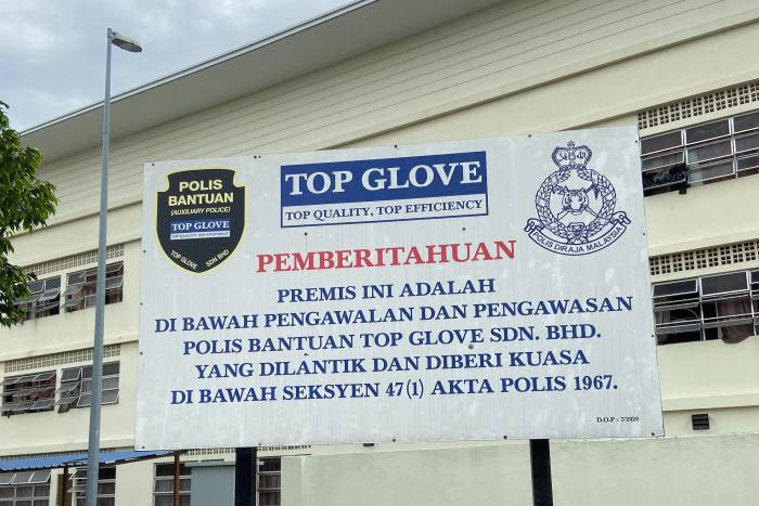 ‘This premises is under the control and surveillance of the auxiliary police,’ reads a sign outside a Top Glove dormitory for workers
