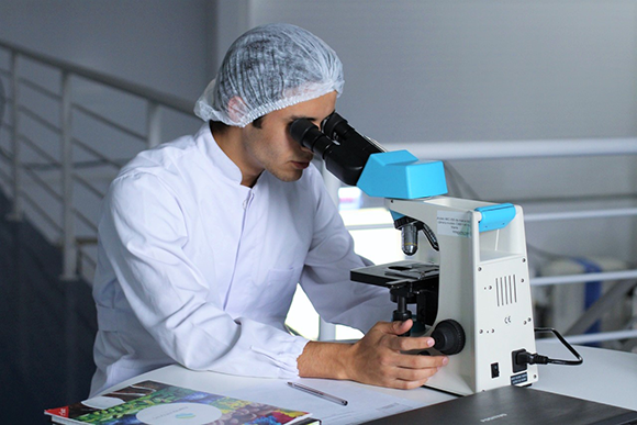 zdjęcie osoby przy mikroskopie