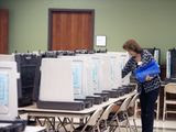 Nacogdoches County Elections Commission worker Peggy Avant doles out pens among voter booths set up at the county courthouse annex ahead of early voting opening on Monday, Friday, Oct. 19, 2018 in Nacogdoches, Texas. (Tim Monzingo/The Daily Sentinel via AP) **FILE**