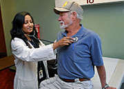 A doctor listens to a patient's heartbeat with a stethoscope. 