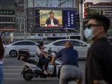 People wearing face masks to protect against the new coronavirus wait to cross an intersection as a large video screen shows Chinese President Xi Jinping speaking in Beijing, Tuesday, June 30, 2020. China approved a contentious national security law that will allow authorities to crack down on subversive and secessionist activity in Hong Kong, a move many see as Beijing&#39;s boldest yet to erase the legal firewall between the semi-autonomous territory and the mainland&#39;s authoritarian Communist Party system. (AP Photo/Mark Schiefelbein)