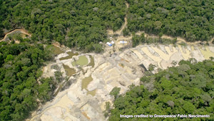 Aerial picture of rainforest with a mining site in the middle.