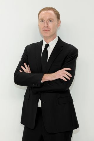 Image may contain Suit Clothing Formal Wear Tuxedo Coat Blazer Jacket Adult Person Portrait Head and Photography