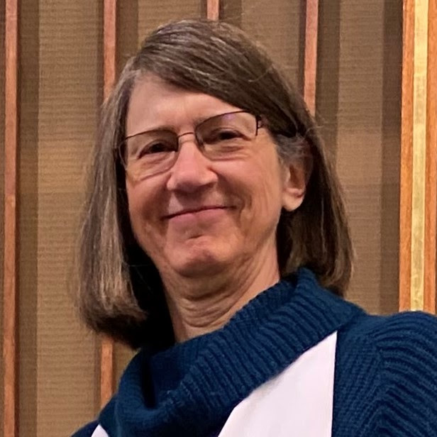white woman with shoulder length hair, wearing glasses
