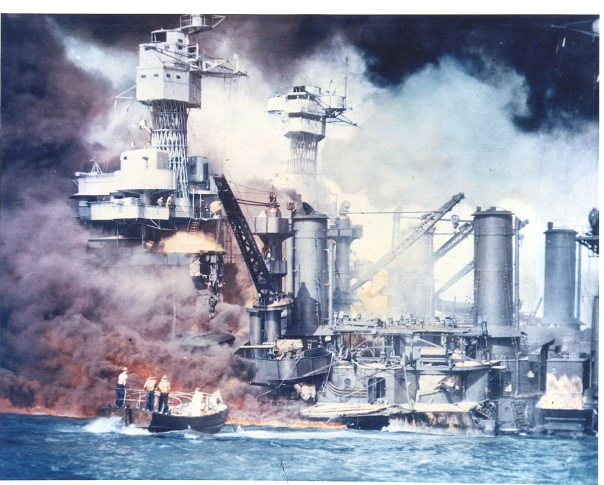 Color photograph of the bombing of Pearl Harbor, showing smoke and fire on the water